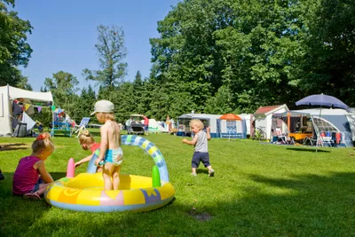 Spielende Kinder im Gras vor dem Zeltplatz auf dem Campingplatz Aan Veluwe
