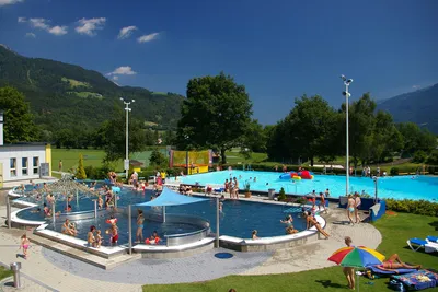 Alpencamp Kärnten - Poolbereich mit Liegestühlen und Sonnenschirmen