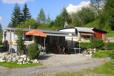 Alpencamp Marienberg - Camper sitzen unter der Markise ihres Wohnwagens