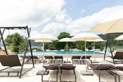 Alpsee Camping - Campingplatz mit Pool Liegestühlen und Sonnenschirmen