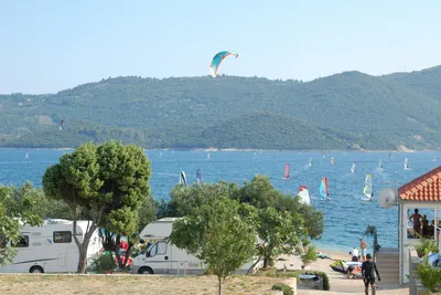 Camping Antony-Boy - Wohnwagenstellplätze mit dem Mittelmeer im Hintergrund, auf dem viele Menschen surfen