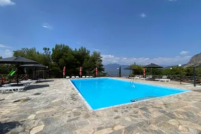 Camping Apollon - Campingplatz mit Pool, Liegestühlen und Sonnenschirmen
