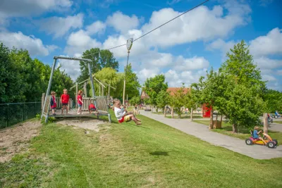 Ardoer Camping International  - Kinder auf dem Spielplatz vom Campingplatz auf grüner Wiese
