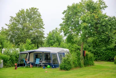 Ardoer Camping Ginsterveld - Campingzelt auf dem Campingplatz vor dem eine Frau die Sonne genießt