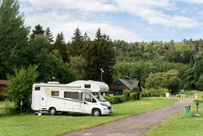 Autokamp Sedmihorky  - Standplätze mit einem Wohnmobil und umringt von Wald mit Blick auf Gebäude
