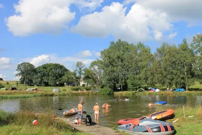 Camping Aux Sources de Lescheret -Gäste liegen auf dem See in der Sonne