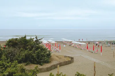 Camping Belmare  -  Strand vom Campingplatz mit Sonnenschirmen und Liegestühlen