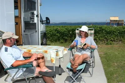 Broager Strand Camping - Camper auf dem Wohnwagen- und Zeltstellplatz mit Blick auf die Ostsee, Spielplatz vom Campingplatz im Hintergrund