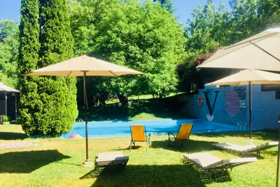 Camping Alta Ribagorça - Pool mit Liegestühlen und Sonnenschirmen auf dem Campingplatz