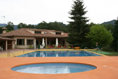 Camping De Vidrà - Pool mit Liegestühlen und Sonnenschirmen auf dem Campingplatz