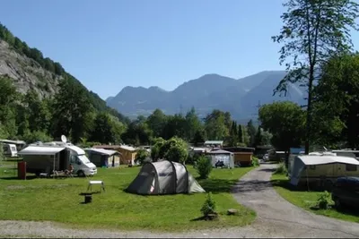 Camp Au -  Wohnwagen- und Zeltstellplatz zwischen Bäumen mit den Alpen im Hintergrund