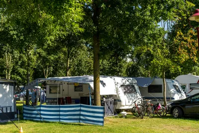 Camping- und Ferienpark Markgrafenheide - Wohnwagen auf dem Wohnwagen- und Zeltstellplatz vom Campingplatz zwischen Bäumen