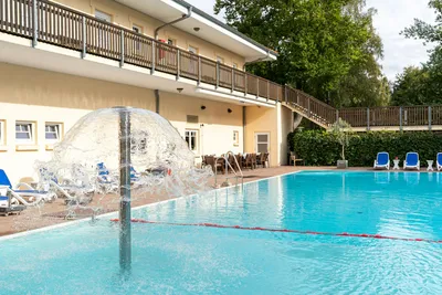 Camping- und Ferienpark Markgrafenheide  - Pool im Freien mit Liegestühlen und Sonnenschirmen