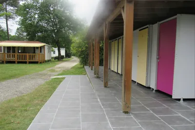 Camping L' Orée du Bois - Sanitärgebäude vom Campingplatz und Mobilheim im Hintergrund