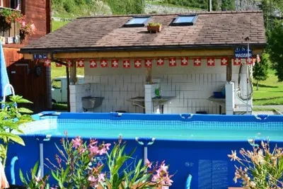 Camping Aareschlucht - Schwimmbecken auf dem Campingplatz mit Waschgebäude im Hintergrund