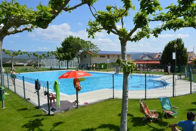 Camping Acedo - Pool mit Liegestühlen und Sonnenschirmen auf dem Campingplatz