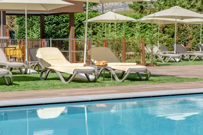 Camping Alleghe - Liegestühle unter Sonnenschirmen am Swimmingpool des Campingplatzes