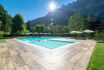 Camping Alleghe - Swimmingpool mit Liegestühlen und Sonnenschirmen am Rand