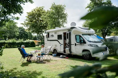 Camping am Deich - Nordsee - Gäste entspannen sich auf ihrem Wohnwagenstellplatz