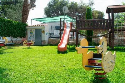 Camping Arena Blanca - Kinderspielplatz des Campingplatzes mit Rutsche, Wippen und Klettergebäude
