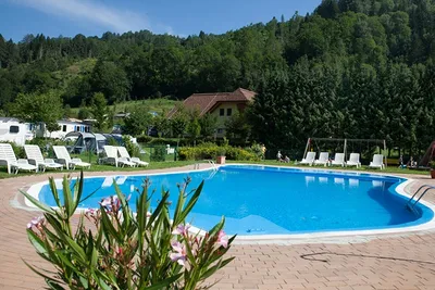 Camping Bella Austria -  Campingplatz mit Pool, Liegestühlen und Sonnenschirmen im Grünen
