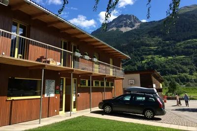 Camping Boomerang - zweistöckiges Gebäude auf dem Campingplatz mit Parkplätzen davor
