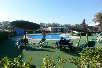 Camping Cabo de Gata  -  Camper am Pool vom Campingplatz mit Sonnenschirmen und Liegestühlen