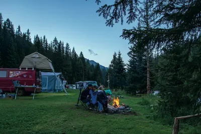 Camping Chapella - Camper am Lagerfeuer auf dem Campingplatz am Wald 