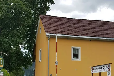 Camping Club Hinterberg - Einfahrt mit Sperrschranke zum Eingangsgebäude des Campingplatzes