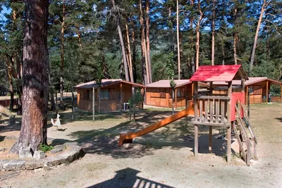 Camping Cobijo - Spielplatz und Mobilheime zwischen Bäumen