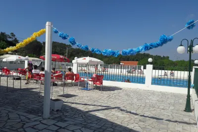 Camping Colina do Sol - Terrasse des Swimmingpools mit Sitzgelegenheiten und Sonnenschirmen