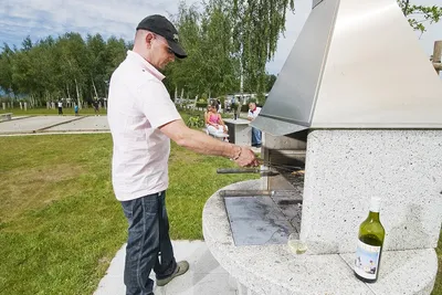 Camping Communal Le Chablais - Camper beim Grillen an einem öffentlichen Steingrill  auf dem Campingplatz