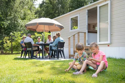 Camping De Binnenvaart Gäste auf der Terrasse eines Mobilheims