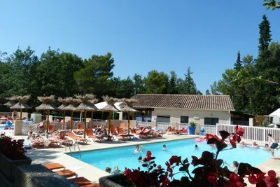 Camping de L' Ayguette - Poolbereich mit Sonnenliegen und Sonnenschirmen