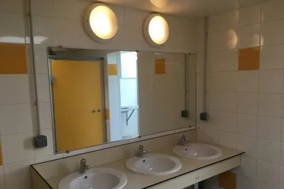 Camping de La Côte des Légendes - Innenraum des Sanitärgebäudes mit Waschbecken und Spiegeln