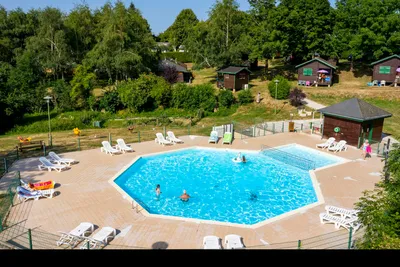 Camping de Tauves  Camping Les Aurandeix - Pool im Freien mit Liegestühlen