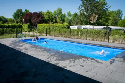 Camping De Uitwijk - Pool im Grünen, Wohnwagen- und Zeltstellplatz vom Campingplatz im Hintergrund
