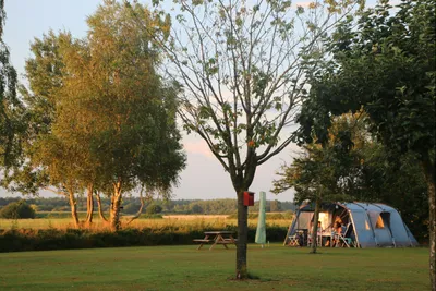 Camping Weideblik - Blick auf einen Standplatz auf der Wiese bei Sonnenuntergang