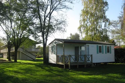 Camping des Varennes  -  Mobilheim vom Campingplatz mit Veranda zwischen Bäumen