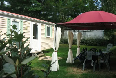 Camping des Varennes  - Außenansicht Mobilheim und Esstisch unter einem Pavillon 