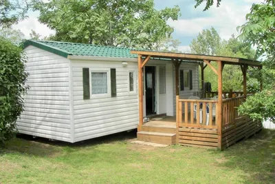 Camping Le Bas Larin  -  Mobilheim zwischen Bäumen auf dem Campingplatz