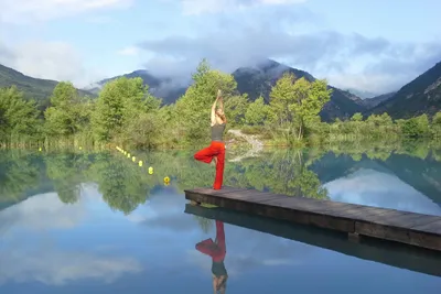 Camping du Brec - Camperin macht Yoga auf einem Steg in Fluss auf dem Campingplatz