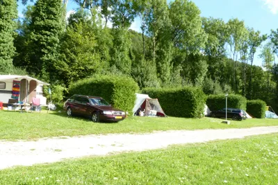 Camping du Gît - Stellplätze umringt von Hecken an einer Strasse des Campingplatzes