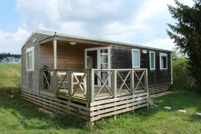 Camping du Lac - Chalet mit Veranda und Sitzgelegenheiten auf dem Campingplatz