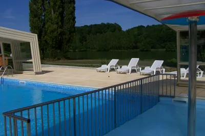Camping du Lac - Pool mit Liegestühlen und Sonnenschirmen auf dem Campingplatz