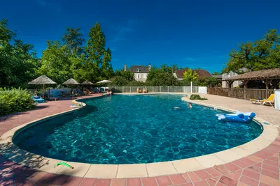 Camping Du Port - Swimmingpool mit Liegestühlen und Sonnenschirmen