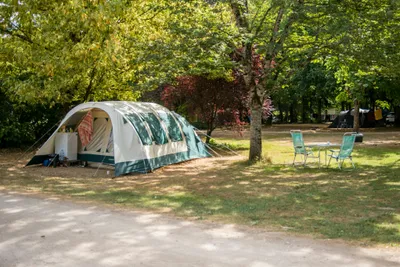 Camping Du Port - Zelt auf einem Stellplatz zwischen Bäumen
