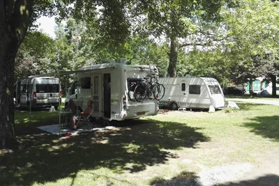 Camping de Bouthezard - vor dem Wohnmobil sitzen Camper im Schatten