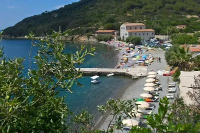 Camping Enfola  -  Strand vom Campingplatz am Mittelmeer mit Sonnenschirmen und Liegestühlen