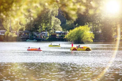 Camping- und Ferienpark Teichmann  -  Camper mit Booten auf dem Teich am Campingplatz, Stellplatz im Hintergrund